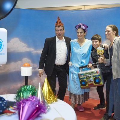 Besucher der Gala lassen sich vor einer Fotowand fotografieren. Sie tragen dabei Kost&uuml;me und H&uuml;te.