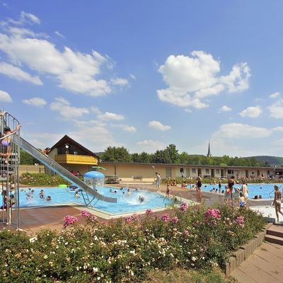 Die Rutsche und das Schwimmbecken des Freibades in Thüngersheim ist gut besucht. Etliche Besucher tummeln sich im Wasser.