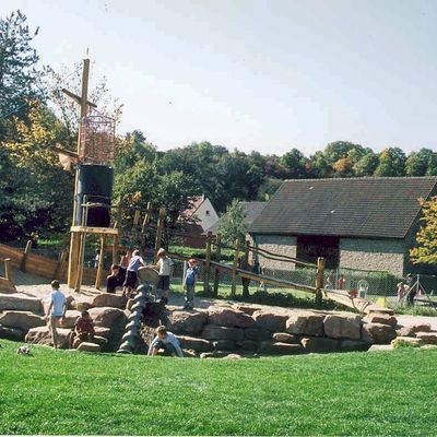 Kinder am spielen in einem nachgebauten Piratenschiff auf einem Spielplatz, der vor anderen H&auml;usern liegt.