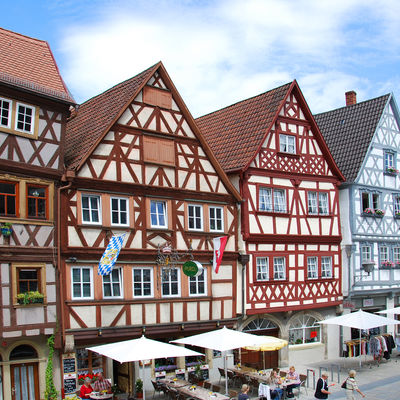 Fachwerkh&auml;user der Gemeinde Sommerhausen mit Sonnenschirmen und Sitzm&ouml;glichkeiten davor.
