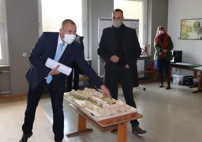 Noch ist es nur ein Modell, doch schon ab dem kommenden Jahr soll die Neue Mitte Uettingen Realit&auml;t werden. Landrat Thomas Eberth (l.) und Architekt Roland Breunig zeigen die Pl&auml;ne f&uuml;r das Ensemble aus Alter und Neuer Schule sowie dem ehemaligen Kr&auml;merhof