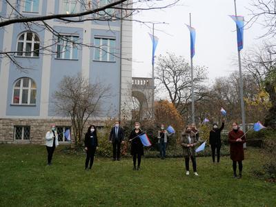 In diesem Jahr hissten Landrat Thomas Eberth (3.v.l.) und Carmen Schiller (2.v.l.), kommunale Gleichstellungsbeauftragte des Landkreises W&uuml;rzburg, die Fahnen zusammen mit einer Corona-bedingt kleineren Delegation von jungen Frauen. 