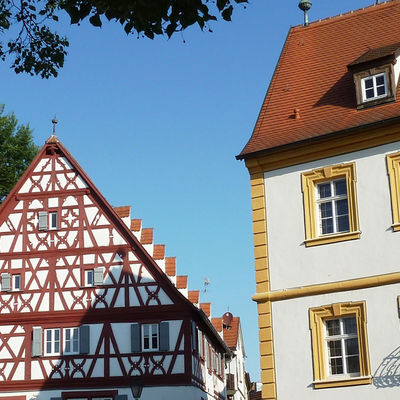 Zwei H&auml;user, von denen eines ein Fachwerkhaus ist, neben einer Kirche.