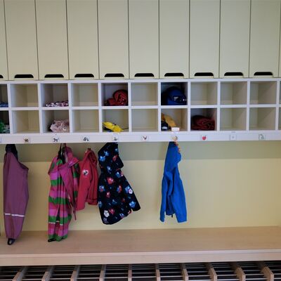 Eine Garderobe in einem Kindergarten. Es h&auml;ngen mehrere Jacken an den Kleiderharken.