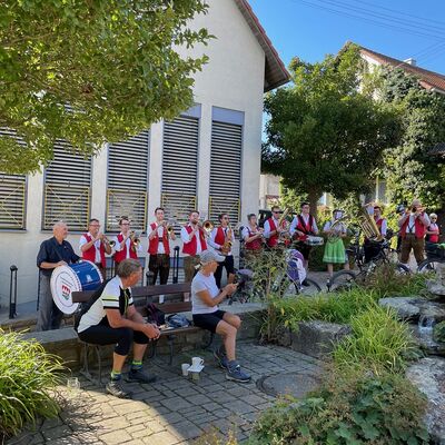 Eine Musikkappelle spielt vor einem Geb&auml;ude.