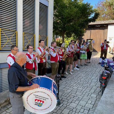 Eine Musikkappelle spielt vor einem Geb&auml;ude.