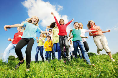 Kinder laufen durch Wiese