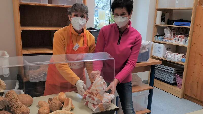 Bild vergrößern: Helferin Barbara Müller und Gudrun Beck vom Landratsamt Würzburg richteten die Lebensmittel an der Tafel in Ochsenfurt.